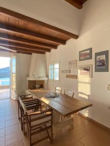 a dining room with a wooden table and chairs at Astra Serifos in Livadi
