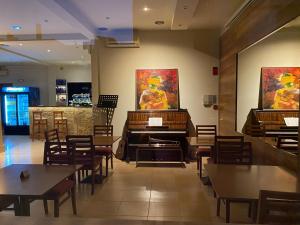 a restaurant with a piano and tables and chairs at Moudania Mare in Nea Moudania