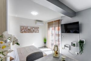 a white room with a bed and a tv at Luxury apartments Budimir in Podstrana