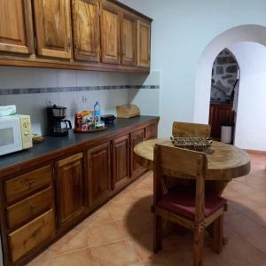 a kitchen with wooden cabinets and a small table at Casa Galante in Furnas