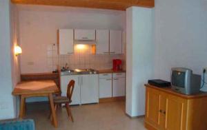 a small kitchen with a table and a tv at Apartments in Kaltenbach/Zillertal 751 in Kaltenbach