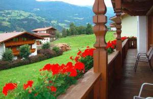 a balcony with red flowers in a yard at Apartments in Kaltenbach/Zillertal 751 in Kaltenbach