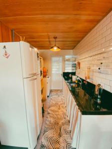 a kitchen with a refrigerator and a counter top at Chalé do Lago in São Francisco de Paula