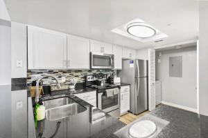 a kitchen with white cabinets and stainless steel appliances at Kasa Delray Beach South Florida in Delray Beach