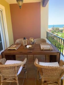 comedor con mesa y sillas en el balcón en Atico en Primera Linea de Playa con Vistas al Mar 3 dormitorios en Isla Canela