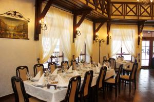 a dining room with long tables and chairs with white table cloth at Chalet Hotel in Zhytomyr