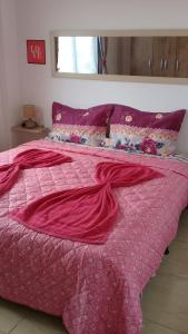 a pink bed with a pink blanket on top of it at Apartamento 3/4 completo em frente ao Aeroporto in Salvador