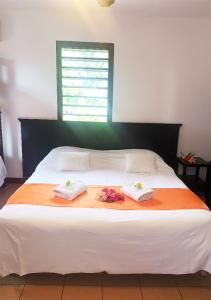 a bedroom with a bed and a window at Hotel Oasis de Kiamu in Lifou