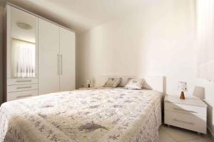 a white bedroom with a large bed and a dresser at Apartment in Ravni/Istrien 8872 in Ravni
