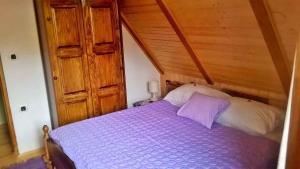 a bedroom with a purple bed with a wooden ceiling at Holiday home in Golik - Gorski Kotar 14249 in Zagolik
