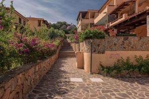 kamienny chodnik prowadzący do budynku z kwiatami w obiekcie Holiday home in Golfo Aranci 30357 w mieście Golfo Aranci