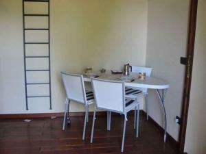 a table with three chairs and a tea kettle on it at Holiday home in Madonna Del Sasso 22866 in Madonna del Sasso