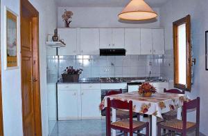 a kitchen with a table with chairs and a kitchen with white cabinets at Apartments in Capoliveri/Insel Elba 23660 in Capoliveri