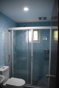 La salle de bains est pourvue d'une douche en verre et de toilettes. dans l'établissement La Casa Vacanze PH Private villa w/ swimming pool, à Batangas City