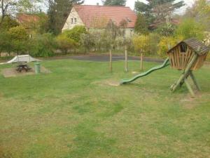un parque con un parque infantil con un tobogán en el césped en Apartments in Trebbin 26568, en Trebbin