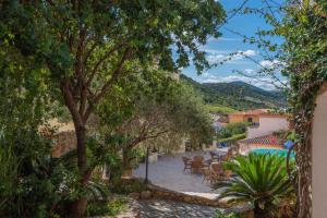 ブドーニにあるHoliday home Budoni - Insel Sardinien 27734のプール、テーブル、木々が備わるリゾートです。