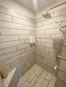 a bathroom with a shower with a wooden wall at The Rooms at Woody Point in Bonne Bay