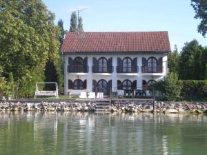 uma casa na costa de um corpo de água em Holiday Homes in Balatonszarszo 20090 em Balatonszárszó