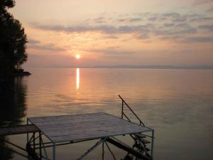 drewniana przystań w środku wody w obiekcie Holiday Homes in Balatonszarszo 20090 w mieście Balatonszárszó