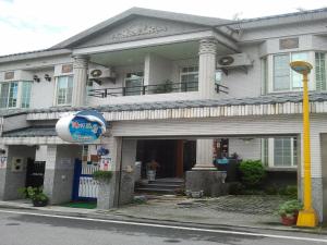 una gran casa blanca con un cartel delante en Hai Yang Feng Qing Homestay, en Hualien City