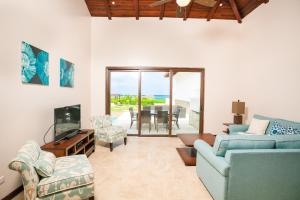a living room with a couch and chairs and a television at Pristine Bay Beach Home 104 in French Harbour