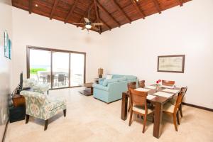 a living room with a table and chairs and a couch at Pristine Bay Beach Home 104 in French Harbour