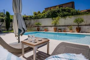 - une piscine avec une table et un parasol dans l'établissement SERRENDY Villa in Cap dAntibes near beaches, à Antibes