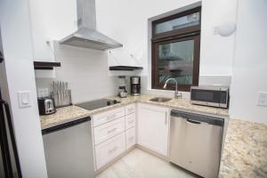 een witte keuken met een wastafel en een vaatwasser bij Bella Luna Beach Condo #227487 in West End