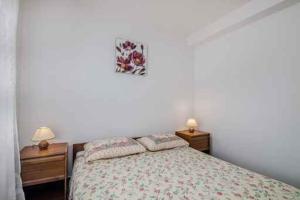 1 dormitorio con 1 cama con 2 mesitas de noche y 2 lámparas en Apartment in Klimno/Insel Krk 14302, en Klimno