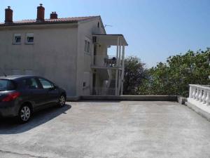 a car parked in a parking lot in front of a house at Apartment in Selce 5818 in Selce