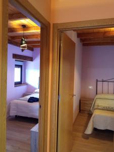 a room with two beds and a door to a bedroom at Casa la ti María la viuda in Riego de Lomba