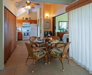 a dining room and kitchen with a table and chairs at Sealodge E10 in Princeville