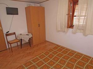a living room with a table and a chair at Apartments in Veli Losinj 14928 in Veli Lošinj