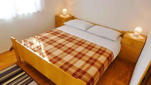 sypialnia z łóżkiem z kocem szachowym w obiekcie Apartments in Dobrinj/Insel Krk 35141 w mieście Dobrinj