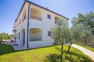 a white house with a tree in front of it at Apartment in Nova Vas - Istrien 35437 in Nova Vas