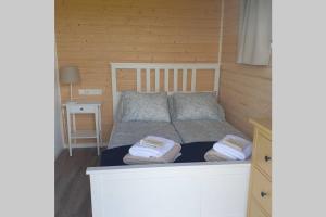 a bedroom with a bed with two towels on it at Hólmasel Riverside Cabin 1 in Arabaer