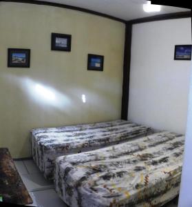 a bedroom with two beds and pictures on the wall at Benu Suítes in Jericoacoara +8 photos