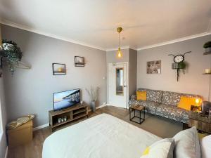 a living room with a couch and a tv at Westend Holiday Room 4 Brecon in Brecon