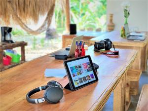 una mesa con una tablet y auriculares. en Isla Fuerte - Wiji Island House, en Puerto Limón