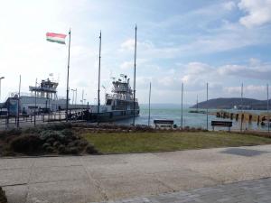 a couple of boats docked at a dock with a flag at Holiday home in Szantod - Balaton 31357 in Szántód
