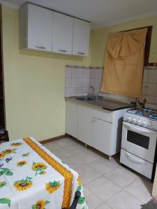 une cuisine avec un évier et une cuisinière dans l'établissement Cabaña vivir #2, à El Chalten 13 autres photos