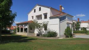 ein weißes Haus mit einem Pavillon im Hof in der Unterkunft Apartments in Vantacici - Insel Krk 13154 in Vantačići