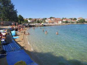 eine Gruppe von Menschen im Wasser an einem Strand in der Unterkunft Apartments in Vantacici - Insel Krk 13154 in Vantačići + 4 Fotos