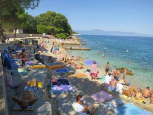 eine Gruppe von Menschen an einem Strand mit dem Wasser in der Unterkunft Apartments in Vantacici - Insel Krk 13154 in Vantačići