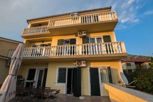 スタリグラードにあるApartments in Starigrad-Paklenica 6891のバルコニーとテーブルと傘のある黄色い家