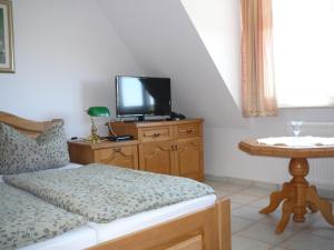 a bedroom with a bed and a tv on a wooden cabinet at Rezydencja Nad Jeziorem Łebsko in Łeba