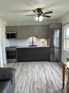 a kitchen with a couch and a ceiling fan at Newly Renovated Confederation Bridge View Cottages in Borden