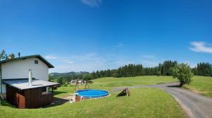 a house with a swimming pool in a field at Holiday home Benecko/Riesengebirge 2230 in Benecko