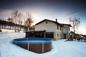 a house with a swimming pool in the snow at Holiday home Benecko - Riesengebirge 2230 in Benecko
