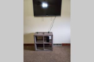 una pequeña mesa de madera con TV en la pared en Nice and cozy home for a business or family stay., en Johnstown